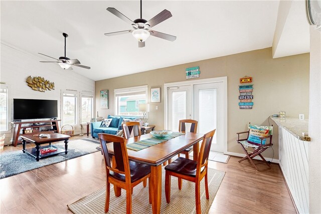 dining room featuring lofted ceiling, french doors, ceiling fan, and light hardwood / wood-style flooring