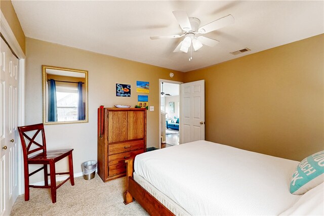 carpeted bedroom featuring ceiling fan and a closet