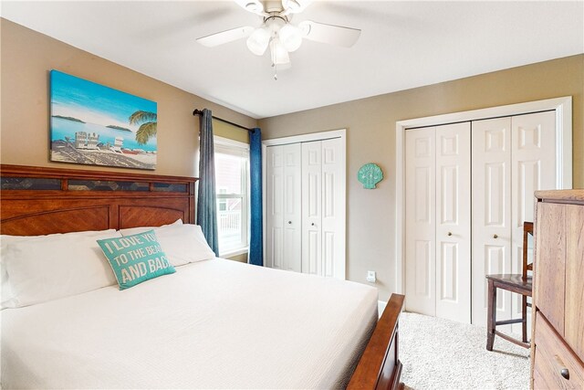 carpeted bedroom with ceiling fan and multiple closets