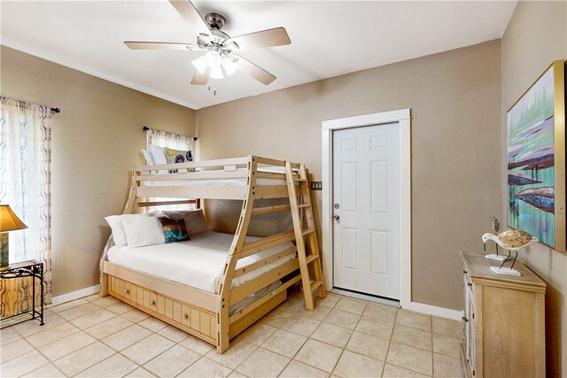 tiled bedroom featuring ceiling fan