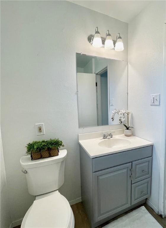 half bathroom with toilet and vanity