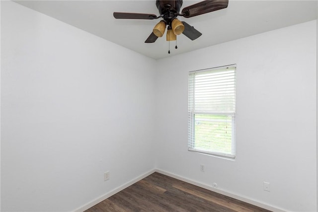 spare room featuring plenty of natural light, baseboards, dark wood-type flooring, and ceiling fan