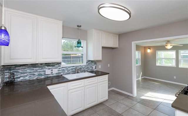 kitchen with a sink, dark countertops, and tasteful backsplash