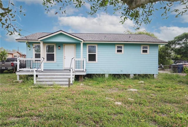 back of property featuring a yard, fence, and a wooden deck