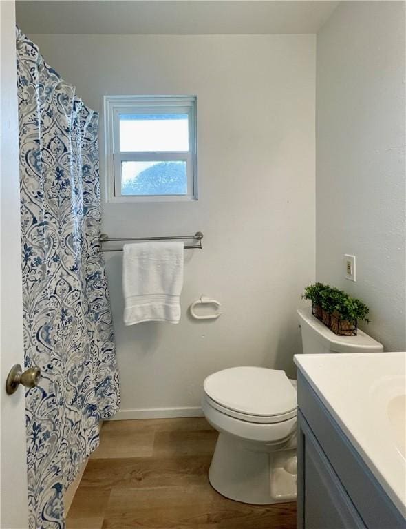 full bathroom with vanity, wood finished floors, curtained shower, toilet, and baseboards