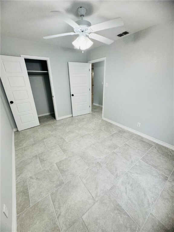 unfurnished bedroom with a closet and ceiling fan