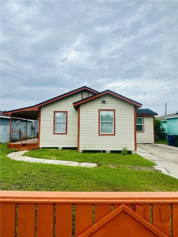 view of side of property featuring a lawn and a carport