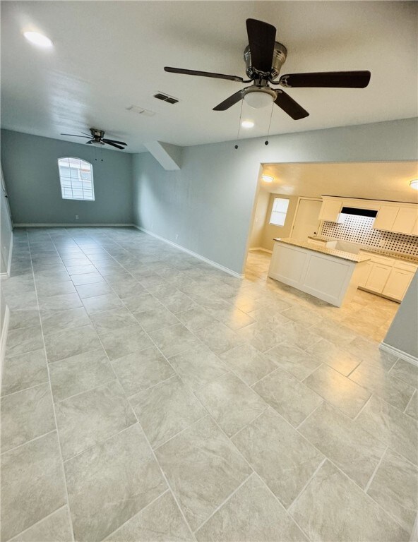 unfurnished living room with ceiling fan