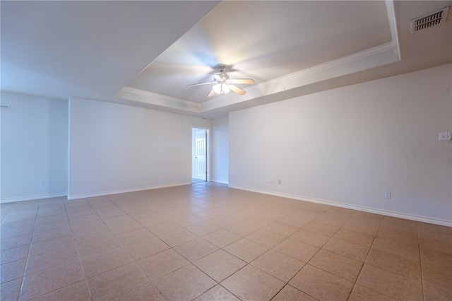 tiled empty room featuring ceiling fan, ornamental molding, and a tray ceiling