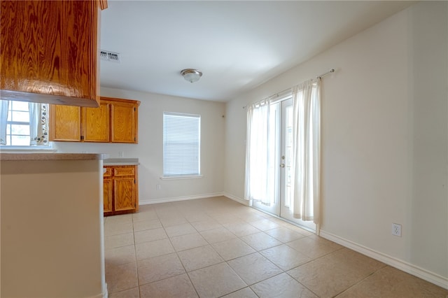 kitchen featuring plenty of natural light, light tile patterned floors, and french doors