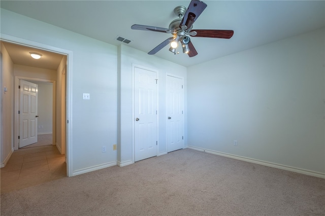 unfurnished bedroom featuring ceiling fan and light carpet