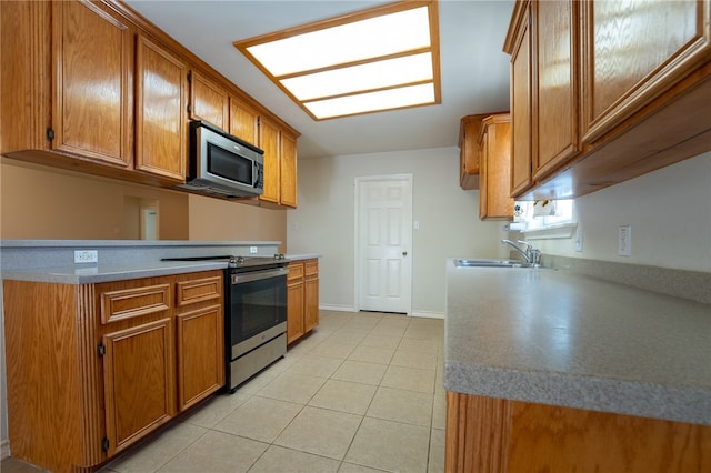 kitchen with sink, light tile patterned floors, and stainless steel appliances