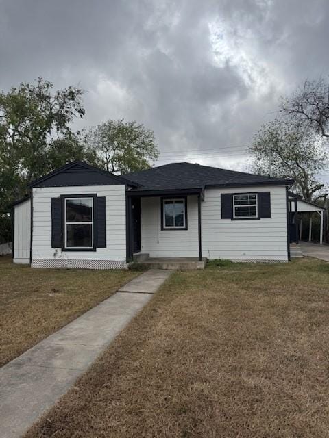 ranch-style home with a front yard and a carport