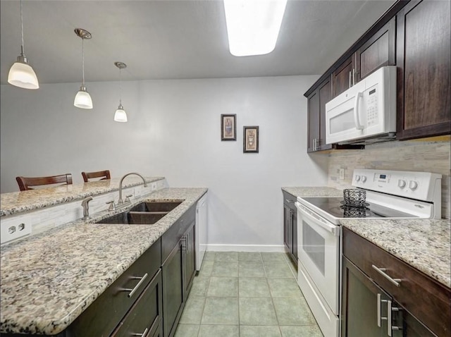 1011 Ennis Joslin Unit 224, Corpus Christi, TX 78412 - kitchen with white appliances, a sink, baseboards, and dark brown cabinetry