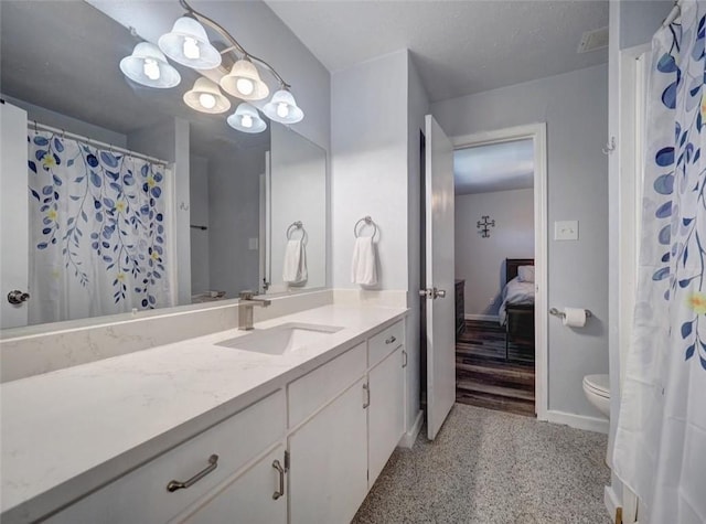 1011 Ennis Joslin Unit 224, Corpus Christi, TX 78412 - ensuite bathroom with vanity, toilet, baseboards, and a shower with shower curtain