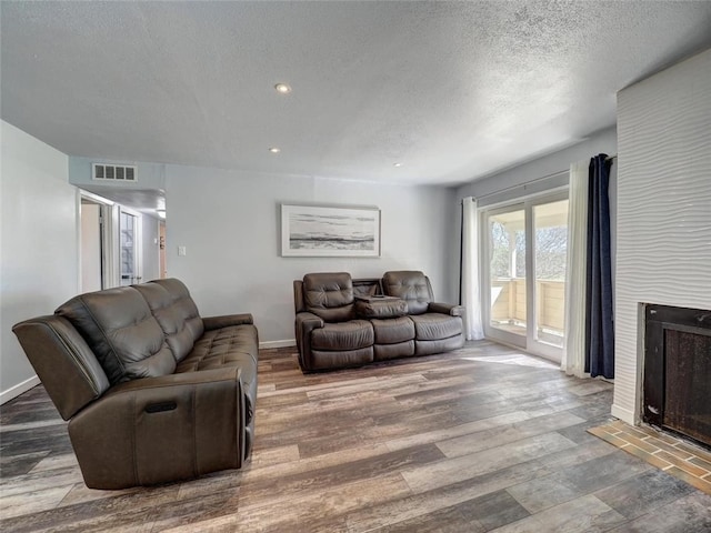 living room with wood-type flooring and a textured ceiling