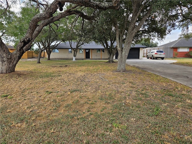 ranch-style home featuring a garage and a front yard