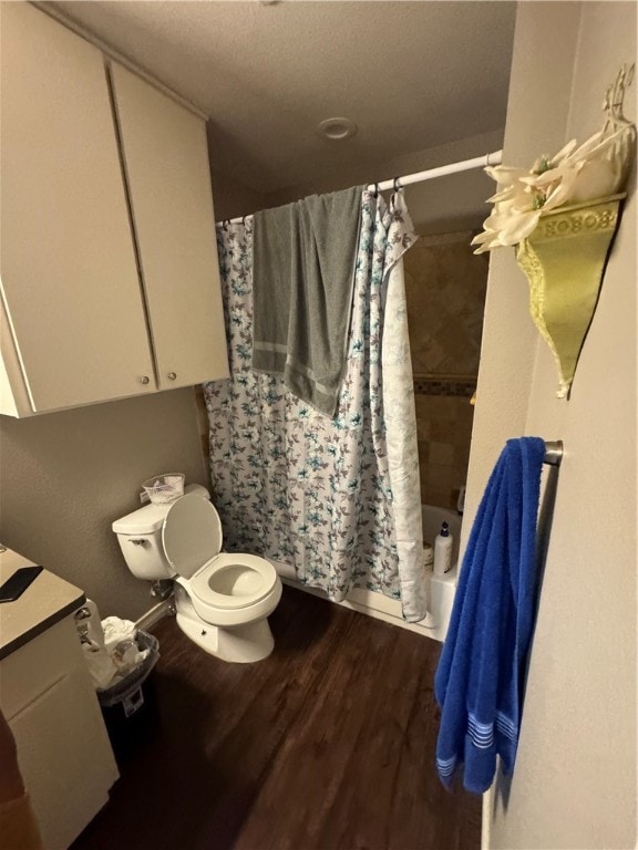 full bathroom with vanity, toilet, shower / bathtub combination with curtain, and hardwood / wood-style flooring