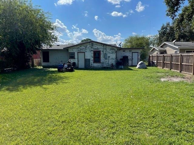 rear view of property featuring a lawn