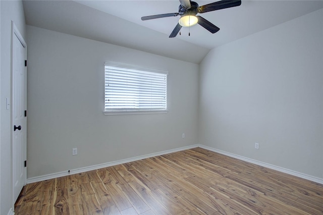 empty room with ceiling fan, lofted ceiling, and light hardwood / wood-style floors