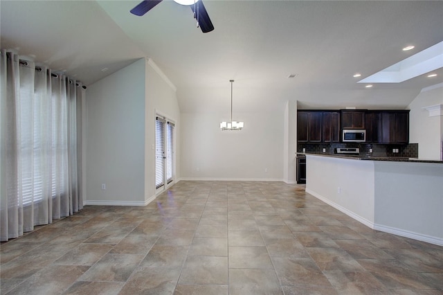 kitchen with plenty of natural light, dark brown cabinets, ceiling fan with notable chandelier, and decorative light fixtures