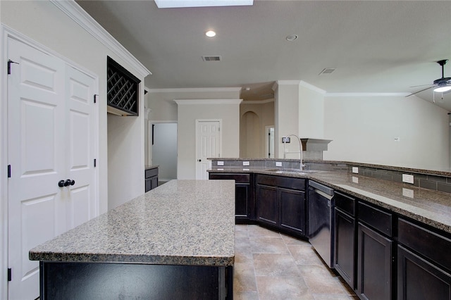 kitchen featuring sink, ceiling fan, a center island, light stone countertops, and stainless steel dishwasher