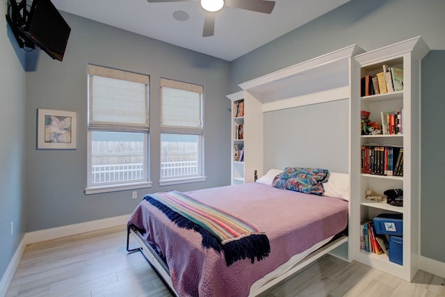 bedroom featuring ceiling fan, baseboards, and wood finished floors