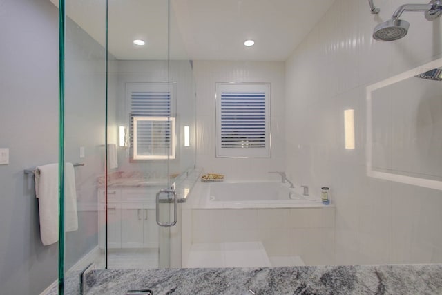 bathroom featuring a stall shower and a bath