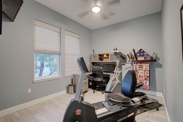 exercise room with ceiling fan, wood finished floors, and baseboards