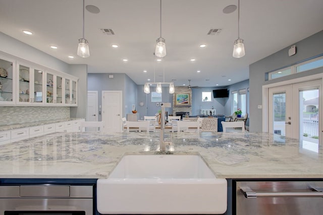 102 Angelfish Ct, Aransas Pass, TX 78336 - kitchen with dishwasher, a sink, open floor plan, white cabinetry, and hanging light fixtures