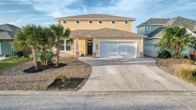 view of front of house featuring a garage, concrete driveway, and fence