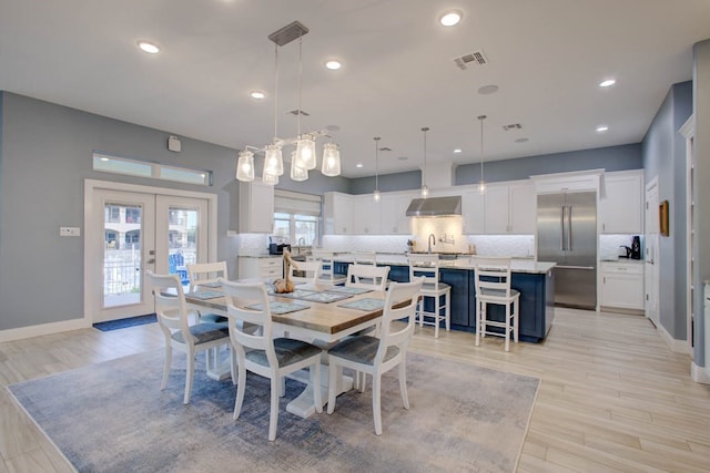 dining area featuring baseboards, french doors, visible vents, and light wood-style floors