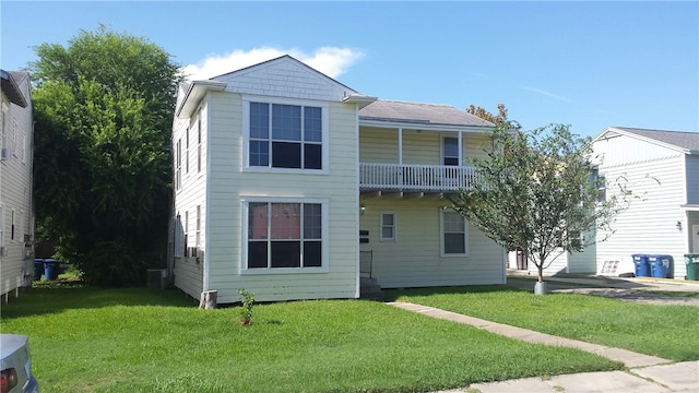 view of front of home with a balcony and a front lawn