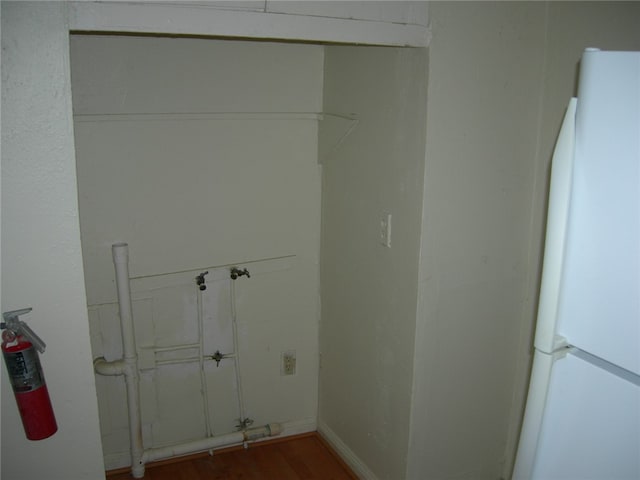 clothes washing area featuring dark wood-type flooring