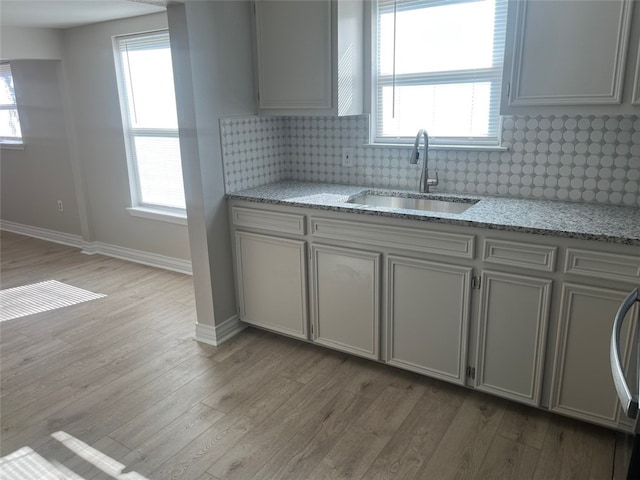 kitchen with sink, a healthy amount of sunlight, and light hardwood / wood-style floors