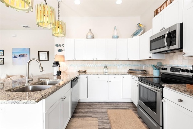 133 Barnacle Dr, Rockport, TX 78382 - kitchen featuring a peninsula, a sink, stainless steel appliances, white cabinets, and tasteful backsplash