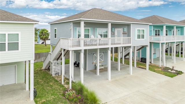 133 Barnacle Dr, Rockport, TX 78382 - back of property with stairway, roof with shingles, a lawn, a carport, and driveway