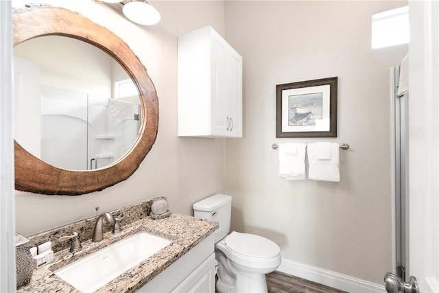 133 Barnacle Dr, Rockport, TX 78382 - full bathroom featuring vanity, wood finished floors, baseboards, an enclosed shower, and toilet