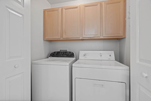 laundry room featuring cabinets and washer and clothes dryer