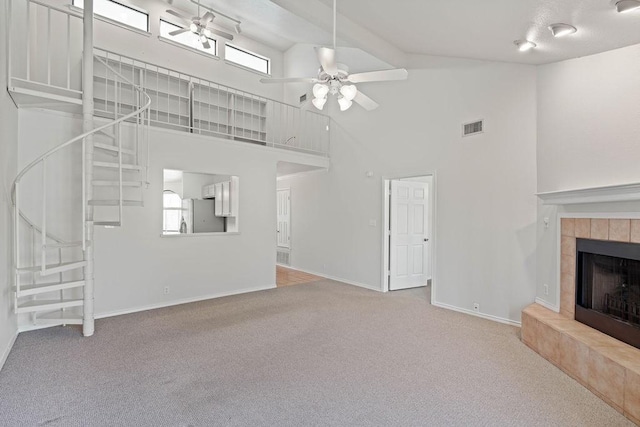 unfurnished living room with ceiling fan, carpet floors, a fireplace, and high vaulted ceiling