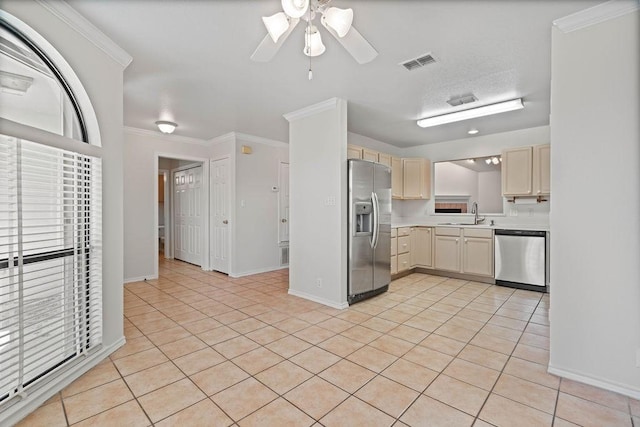 kitchen with appliances with stainless steel finishes, sink, light tile patterned floors, ceiling fan, and crown molding