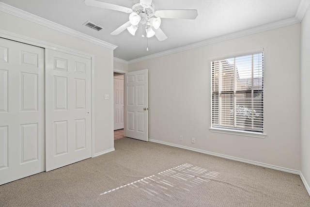 unfurnished bedroom with light carpet, ornamental molding, a closet, and ceiling fan