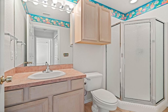 bathroom featuring an enclosed shower, vanity, and toilet