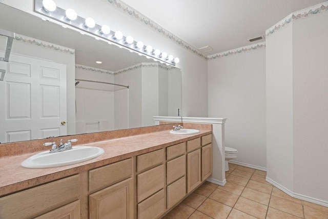 bathroom featuring vanity, walk in shower, tile patterned floors, and toilet