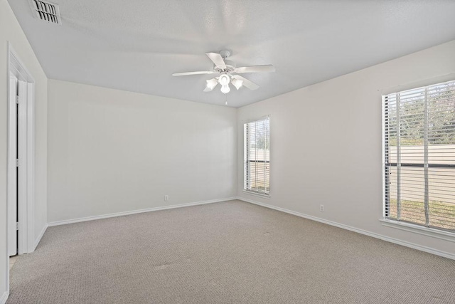 carpeted empty room with ceiling fan and a healthy amount of sunlight