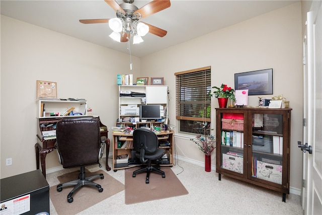 carpeted office featuring ceiling fan