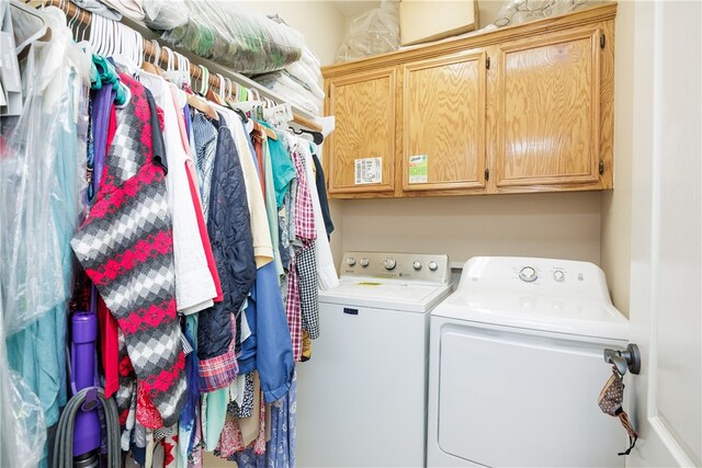 washroom with cabinets and washer and clothes dryer