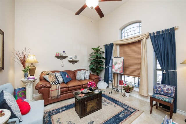 living room featuring a wealth of natural light, ceiling fan, light tile patterned floors, and high vaulted ceiling