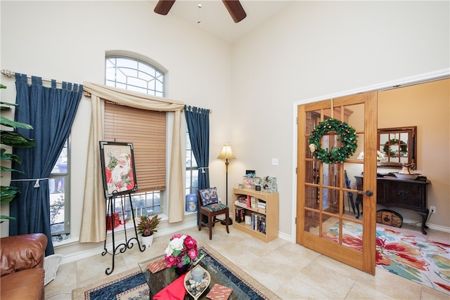 sitting room featuring ceiling fan and high vaulted ceiling