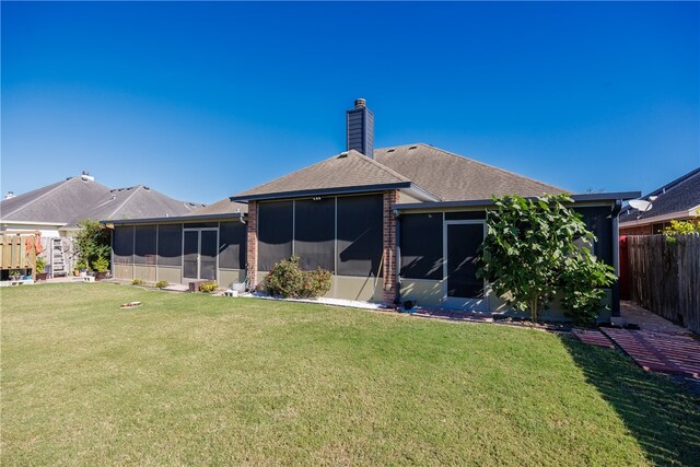 back of property featuring a sunroom and a yard